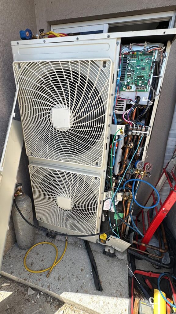 Condensadora aberta com a placa eletrônica exposta durante manutenção
